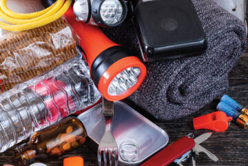 Snapshot of emergency kit items including batteries, flashlight, food and a blanket