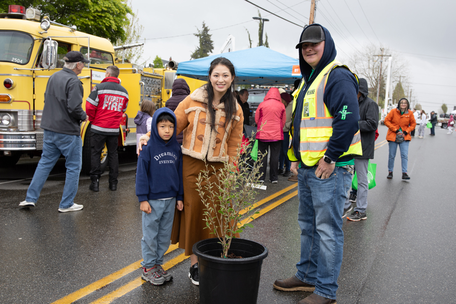 A happy lady and her son pose with a tree prize at the Energy Block Party