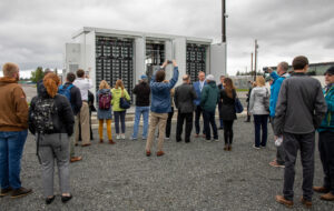 People gathered around a large battery system at the Arlington Microgrid on a gray day