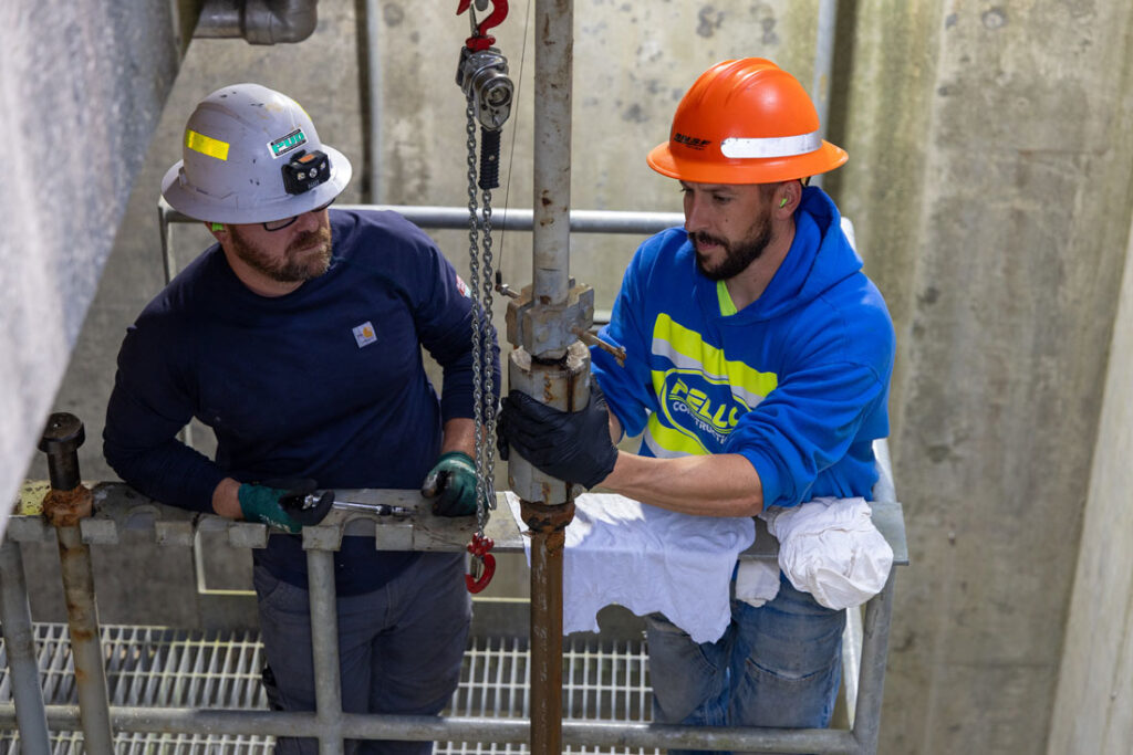 Two workers perform maintenance at Jackson Hydroelectric Project