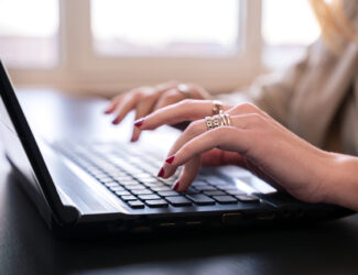 person using keyboard in brightly lit room